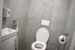 a bathroom with a white toilet and a sink at 2 Cozy Apartment Bialystok in Białystok