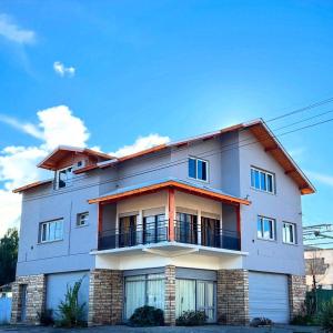 a large white building with a balcony at Hostel 360 Patagonia in El Bolsón +61 photos