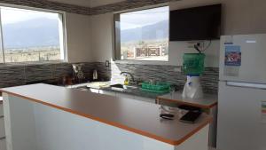 a kitchen with a white counter top and two windows at Al Paraíso in Tafí del Valle