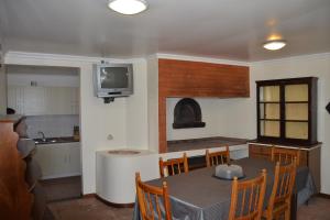 a kitchen and dining room with a table and a tv at Hostel Casal São João in Ribeira Brava