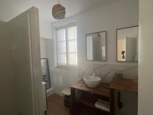 a bathroom with a sink and a toilet and a window at La pause Saumuroise in Saumur