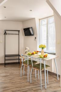 ein Esszimmer mit einem weißen Tisch und Stühlen in der Unterkunft Villa Mona Studio Falaises quartier des Cordiers in Le Tréport + 9 Fotos