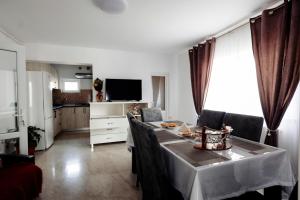 a living room with a table and a kitchen at Acasa La Lumei in Sighetu Marmaţiei