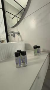three jars sitting on a white counter in a bathroom at Ioli's Apartments Zante in Alykes +13 photos