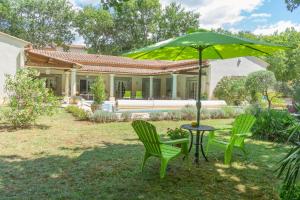 un tavolo e due sedie e un ombrellone in un cortile di Chambre d'Hôte Couguiolet - avec piscine a Foissac