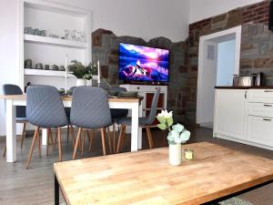 a living room with a table with chairs and a tv at NEU- APPARTMENT in HAGEN nähe DORTMUND - 3 Parking! 3 Double-Bed! 2 Bedrooms, WIFI, COFFEMASHINE-Fully Automatic, KITCHEN, NETFLIX,DISNEY,MAGENTA in Hagen