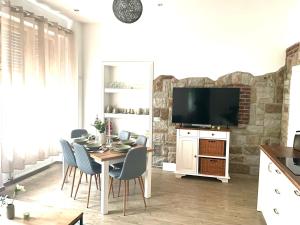 a dining room with a table with chairs and a television at NEU- APPARTMENT in HAGEN nähe DORTMUND - 3 Parking! 3 Double-Bed! 2 Bedrooms, WIFI, COFFEMASHINE-Fully Automatic, KITCHEN, NETFLIX,DISNEY,MAGENTA in Hagen