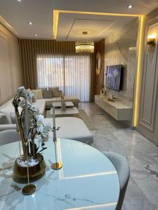 a living room with a table and a couch at Luxury Apartment two bedroom - sea view - best spot in sousse in Sousse