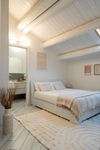 a white bedroom with a large bed and a window at [Ferrara Centro - Karumi Apt] in Ferrara