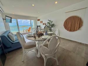 une salle à manger avec une table et des chaises et l'océan dans l'établissement Apartamentos con playa privada y vista al mar, à San Andrés