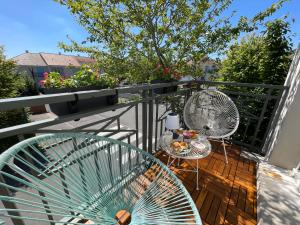 a balcony with two chairs and a table and fan at Duplex Moderne 8per&3Ch&10 min Disney&Parking free in Magny-le-Hongre