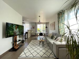 a living room with a couch and a tv at Duplex Moderne 8per&3Ch&10 min Disney&Parking free in Magny-le-Hongre