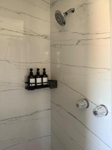 Un baño con ducha con paredes de mármol blanco. en Cozy Private Room in DTLA, en Los Ángeles