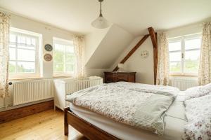 a bedroom with a large bed and two windows at Venkovský dům V Sadu 