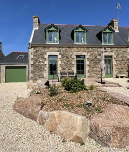 ペロス・ギレックにあるTI GWER - Superbe maison en pierre Ploumanachの犬が前に座っている大きな石造りの家