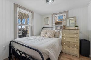 a bedroom with a bed and a dresser with a mirror at Clam Cove - Heart of Hampton Beach in Hampton +17 photos