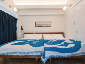 a bedroom with a bed with blue and white blankets at Ludens House横浜山下公園 in Yokohama