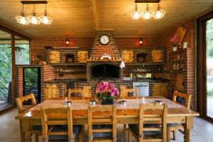 a dining room with a wooden table and a brick wall at Casa Emana in Teşila