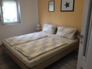 a bed with a comforter on it in a bedroom at Auszeit in Balatonmagyaród