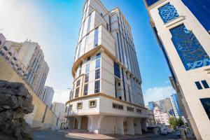 um prédio alto e branco em uma rua da cidade em فندق منازل المقام em Al Khansāk