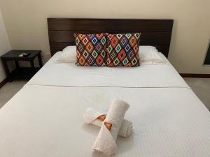 a towel sitting on a bed with a pillow at Hotel Tierra Santa Santa Fe de Antioquia in Santa Fe de Antioquia