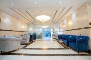 uma sala de espera com cadeiras azuis e um tecto em فندق منازل المقام em Al Khansāk mais 54 fotografias