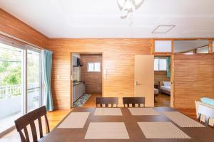 ein Esszimmer mit Tisch und Stühlen in der Unterkunft わったー家あぱらぎ館 in Ishigaki-jima