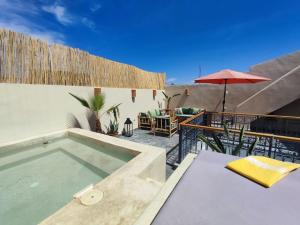 une piscine avec une table et un parasol dans l'établissement Riad E&J Marrakech Médina 5 ch climatisées, piscine chauffée, EXCLUSIF, à Marrakech