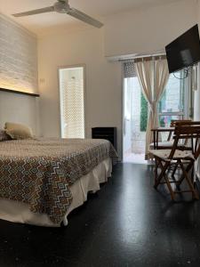 a bedroom with a bed and a flat screen tv at La Casona de Lula y Eduardo in Tandil