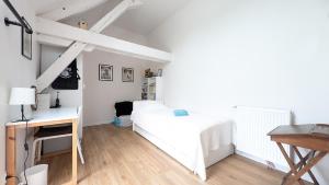 a bedroom with a white bed and a desk at Confort & nature, calme et convivial in Bazoches-sur-Hoëne