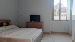 a bedroom with a bed and a flat screen tv at Domus Angelina Pompei in Pompei