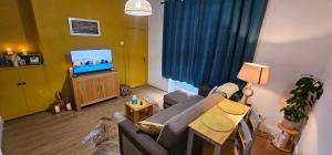 Una sala de estar con un sofá y un televisor. en Homestay, en Aberdeen