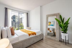 ein Schlafzimmer mit einem großen Bett und einem Spiegel in der Unterkunft Modern Heritage Stay Upscale 2BR in Old Port in Montreal