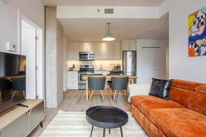 ein Wohnzimmer mit Sofa und eine Küche in der Unterkunft Modern Heritage Stay Upscale 2BR in Old Port in Montreal