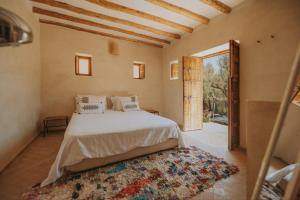 a bedroom with a bed and an open door at Villa La Séguia in Oumnas +39 photos