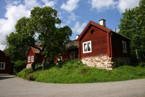 uma casa vermelha numa colina ao lado de um edifício em Sätra Brunn Hälsobrunn em Sätrabrunn