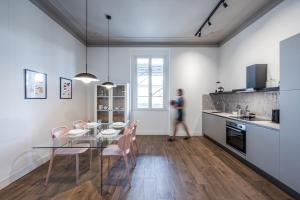a kitchen with a glass table and pink chairs at Luxury by the Sea - Central Design Apartment with AC in Rapallo