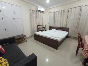 グワーハーティーにあるDorika Homestay, Guwahatiのベッドとソファのある寝室