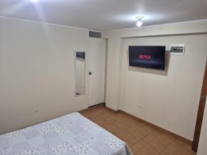 una camera da letto con un letto e una TV a parete di Habitación privada 2do piso cerca a la Plaza Constitución a Huancayo
