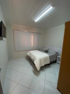 ヴィラ・ヴェーリャにあるPaz e Praia ao Seu Alcanceの白い部屋にあるベッドのある寝室