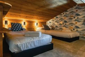 twee bedden in een kamer met houten wanden bij CHALET TEKA LES GETS - Appartement Chery in Les Gets +24 foto's