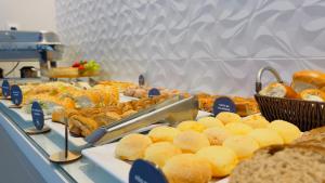 een buffet met verschillende soorten brood en gebak bij Pousada Amanhecer do Sul in Penha +26 foto's
