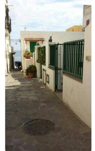 an alley with a building and a gate and a drain at Canneto appartments in Lipari