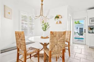 a dining room with a white table and chairs at Tranquil Oasis With Hot Tub, Near Dt & Beach Scene in West Palm Beach