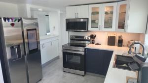 a kitchen with a stainless steel refrigerator and white cabinets at Lemon Tree Retreat in Hudson +6 photos