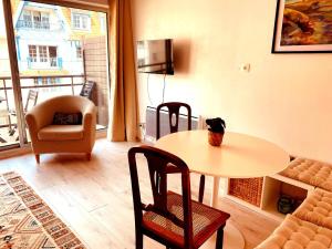 a living room with a table and chairs and a couch at Parenthèse d'Opale Hardelot in Neufchâtel-Hardelot