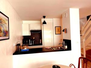 a small kitchen with a sink and a microwave at Parenthèse d'Opale Hardelot in Neufchâtel-Hardelot