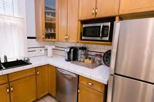 eine Küche mit Edelstahlkühlschrank und Holzschränken in der Unterkunft Ursulines Historic Creole Mansion Steps to QTR Historic Getaways W Pool in New Orleans