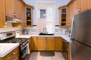 eine Küche mit Holzschränken und einem Edelstahlkühlschrank in der Unterkunft Ursulines Historic Creole Mansion Steps to QTR Historic Getaways W Pool in New Orleans + 51 Fotos