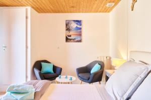 a bedroom with two chairs and a bed and a table at Les chambres de Ma'nous - Dordogne in Mouleydier